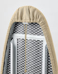 Close-up of an beige ironing board cover fitted to a ironing board, showing the drawstring and the fabric texture.