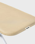 Close-up of a beige ironing board cover rear section with a small white 'bored' brand tag.
