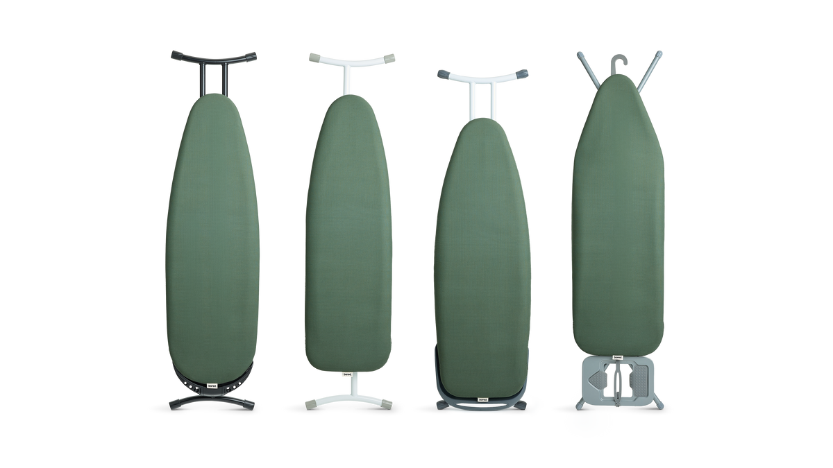 Different freestanding ironing board shapes and sizes in a row, shown from the front, with olive green covers fitted.